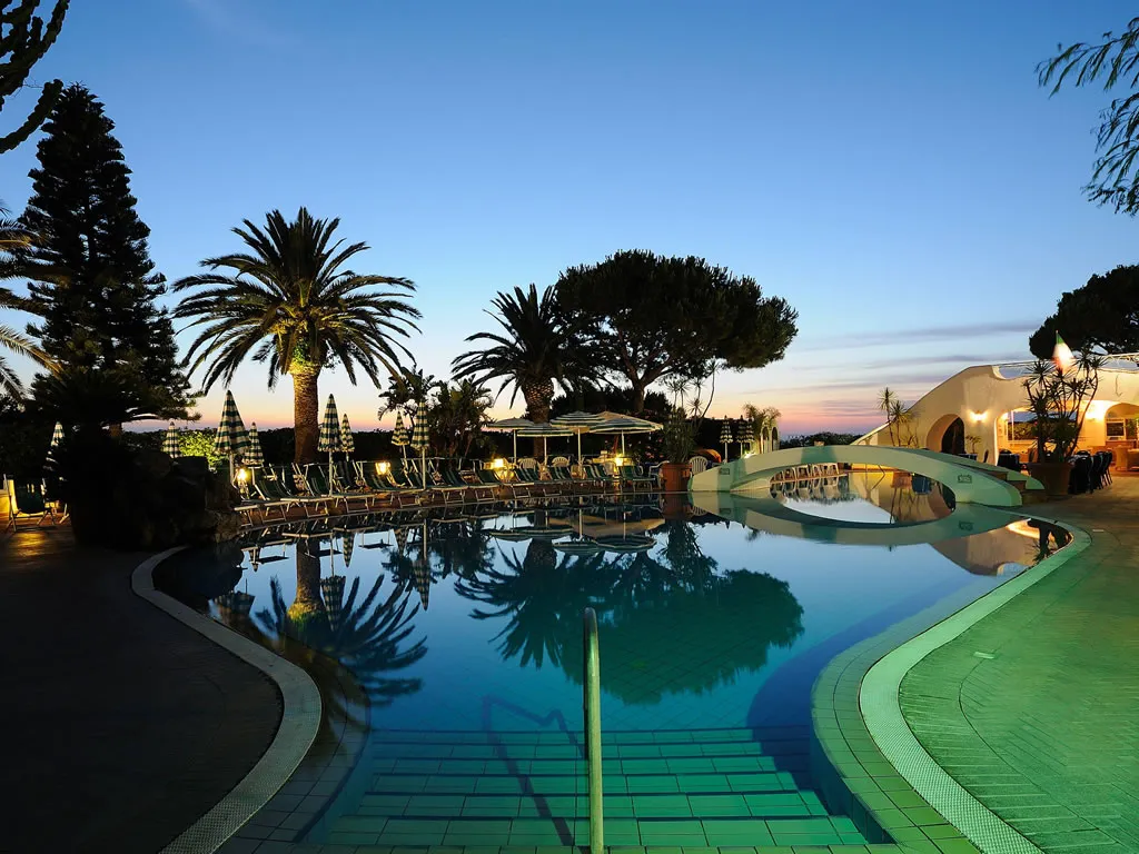 Riflessi serali tra palme e piscina